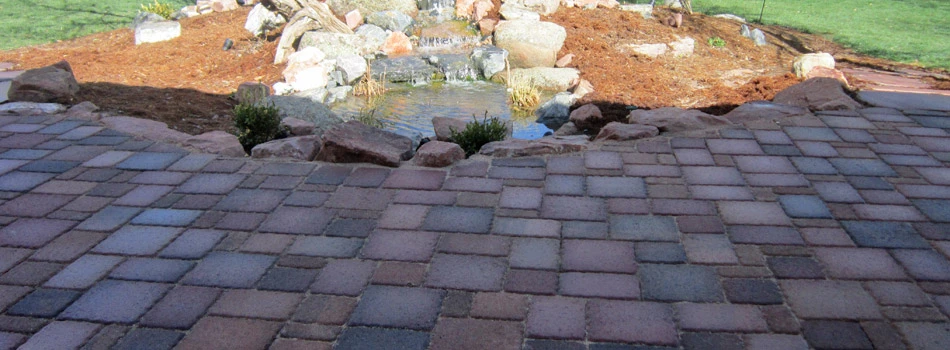 New concrete paver patio installed next to a new water feature on a property in Windsor,CO.