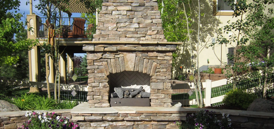Outdoor fireplace built in Loveland that features natural stone.