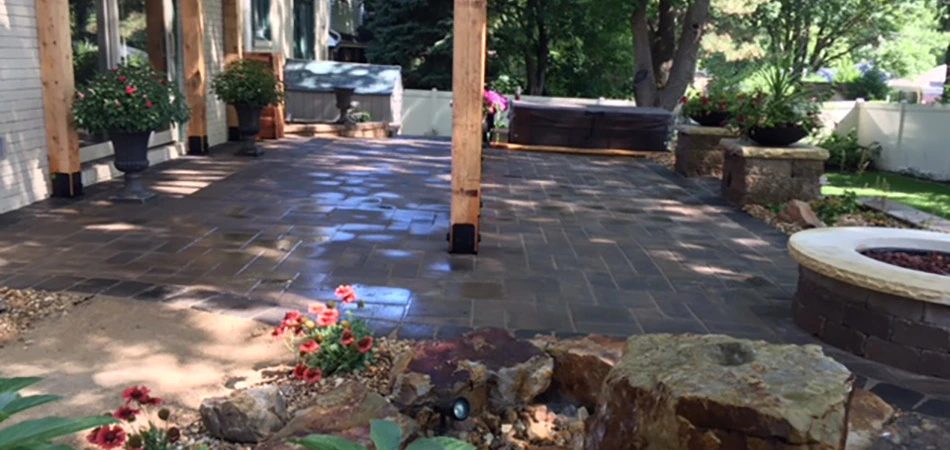 Custom dark paver patio with custom fire pit in Fort Collins, CO.