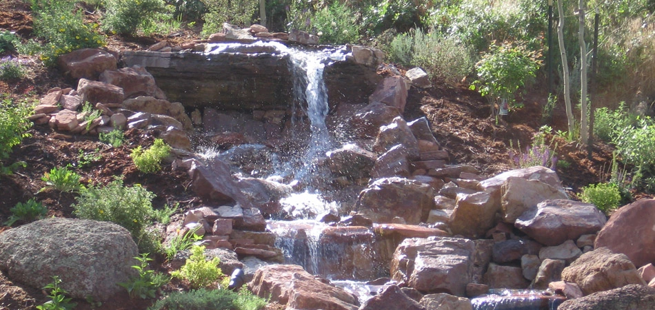 Stacked stone waterfall in Fort Collins that was designed and built by Alive Outside Landscaping.