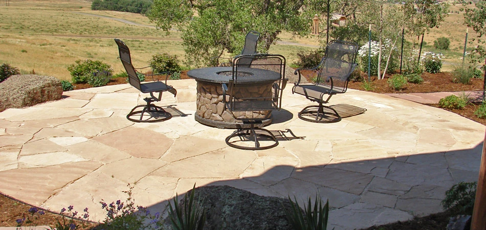 Outdoor fire pit with seating on a custom stone patio in Fort Collins, CO.