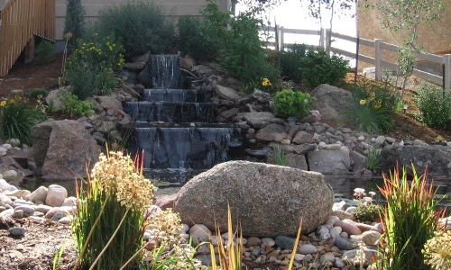 Water fall and boulder landscape in the backyard of a home in Windsor, CO.
